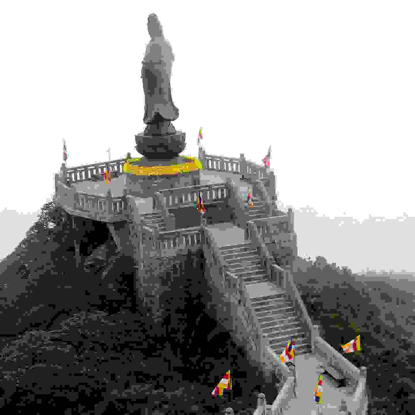 Treppe führt zu einer goldenen Statue hoch, welche mit gelben Blumen dekoriert ist. Der heilige Berg von Sapa. Auslandsseminar der TFBO nach Vietnam.
