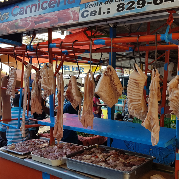 Markt von Higüey. Foto von hängenden Fleischstücken an einem Markt-Stand.
