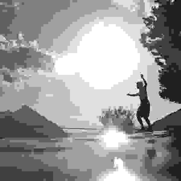 Stimmungsbild: Jemnand balanciert über das Wasser, Sonnen und Berge im Hintergrund.