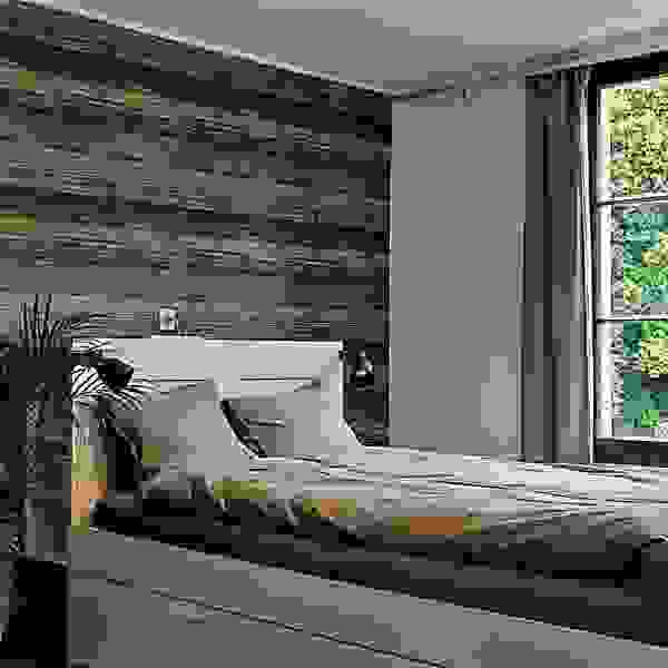 Das Bild zeigt ein Zimmer in einer Ferienwohnung in Grindelwald. Ein Doppelbett vor einer dunkelbraunen Wand, an der rechten Seite des Bildes ist ein Fenster zu sehen.