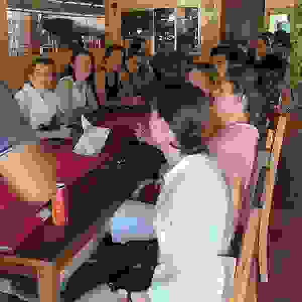 Studierende sitzen während eines Auslandsseminars am Tisch und essen etwas.