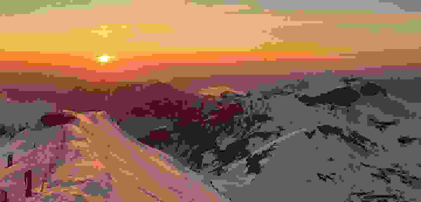 Stimmungsbild: Aussicht von einem Berg auf einen See im Sonnenuntergangs-Licht.